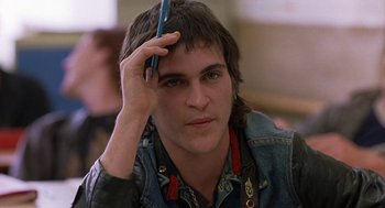 Movie still from “To Die For” (1995), directed by Gus Van Sant – A young man holding a pen to his head; Close Up shot, Over the shoulder angle