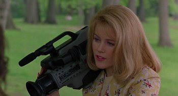 Movie still from “To Die For” (1995), directed by Gus Van Sant – A woman holding a video camera up to her face; Close Up shot, Low angle
