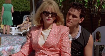 Movie still from “To Die For” (1995), directed by Gus Van Sant – A woman in a pink polka dot jacket and a man in a black t - shirt; Medium shot, Low angle