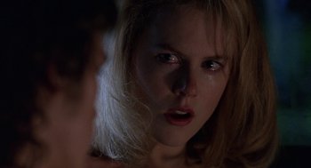 Movie still from “To Die For” (1995), directed by Gus Van Sant – A woman's face in the dark; Close Up shot, Over the shoulder angle