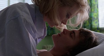 Movie still from “To Die For” (1995), directed by Gus Van Sant – A man and a woman are kissing in a room; Close Up shot, Low angle