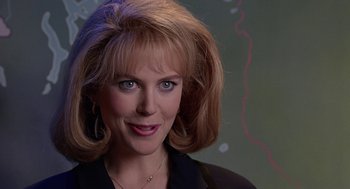 Movie still from “To Die For” (1995), directed by Gus Van Sant – A person with blonde hair and blue eyes; Close Up shot, Over the shoulder angle