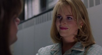 Movie still from “To Die For” (1995), directed by Gus Van Sant – A woman with blonde hair and blue eyes smiling; Close Up shot, Over the shoulder angle