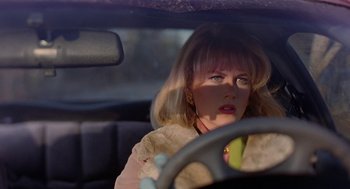 Movie still from “To Die For” (1995), directed by Gus Van Sant – A woman sitting in the driver's seat of a car; Close Up shot, Over the shoulder angle