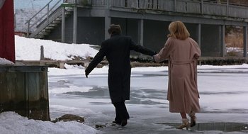 Movie still from “To Die For” (1995), directed by Gus Van Sant – A man and a woman holding hands while standing on a frozen lake; Wide shot, High angle