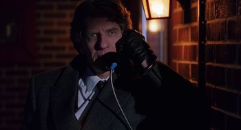 Movie still from “To Die For” (1995), directed by Gus Van Sant – A man in a suit and tie talking on a phone; Close Up shot, Low angle