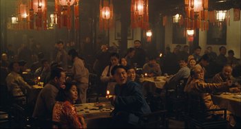 Movie still from “To Live” (1994), directed by Yimou Zhang – A group of people sitting around a table with candles; Wide shot, High angle