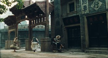 Movie still from “To Live” (1994), directed by Yimou Zhang – An old man sitting in a rickshaw in an asian village; Extreme Wide shot, High angle
