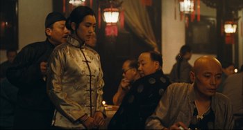 Movie still from “To Live” (1994), directed by Yimou Zhang – A group of people sitting around a table; Medium shot, Over the shoulder angle