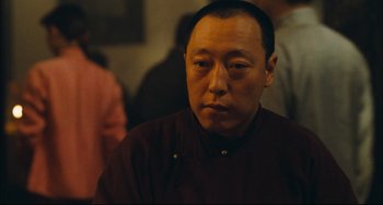 Movie still from “To Live” (1994), directed by Yimou Zhang – A person wearing a red shirt; Close Up shot, Over the shoulder angle
