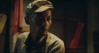 Movie still from “To Live” (1994), directed by Yimou Zhang – A man wearing a hat and a uniform; Close Up shot, Low angle