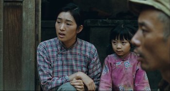 Movie still from “To Live” (1994), directed by Yimou Zhang – A woman sitting next to a little girl; Medium shot, High angle