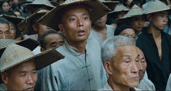 Movie still from “To Live” (1994), directed by Yimou Zhang – A group of men standing next to each other wearing hats; Close Up shot, Low angle