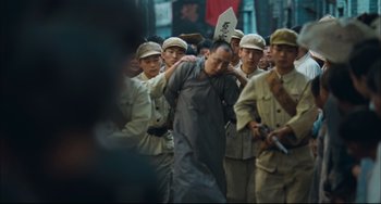 Movie still from “To Live” (1994), directed by Yimou Zhang – A group of men standing next to each other on a street; Wide shot, High angle