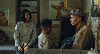 Movie still from “To Live” (1994), directed by Yimou Zhang – A group of people sitting in a room; Medium shot, Over the shoulder angle