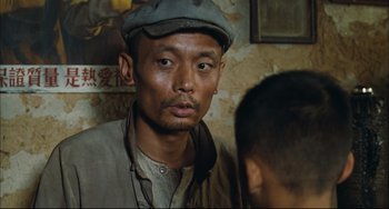 Movie still from “To Live” (1994), directed by Yimou Zhang – A man wearing a hat and looking at the camera; Close Up shot, Low angle