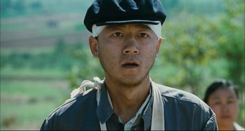 Movie still from “To Live” (1994), directed by Yimou Zhang – A man with a bandage on his head; Close Up shot, Low angle
