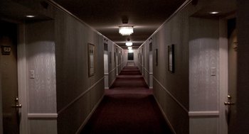 Movie still from “To Live and Die in L.A.” (1985), directed by William Friedkin – A long hallway in a building with a light shining on it; Extreme Wide shot, High angle