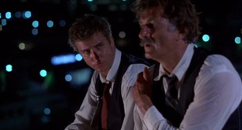 Movie still from “To Live and Die in L.A.” (1985), directed by William Friedkin – Two men in vests and ties are looking at each other; Close Up shot, Low angle