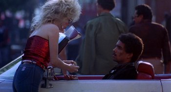 Movie still from “To Live and Die in L.A.” (1985), directed by William Friedkin – A man and a woman sitting at a table talking to each other; Medium shot, Over the shoulder angle
