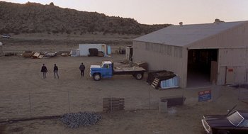 Movie still from “To Live and Die in L.A.” (1985), directed by William Friedkin – A truck parked in front of a building with people standing around it; Extreme Wide shot, High angle