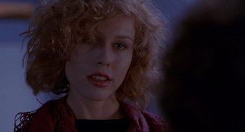 Movie still from “To Live and Die in L.A.” (1985), directed by William Friedkin – A person with curly blonde hair; Close Up shot, Over the shoulder angle