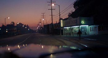 Movie still from “To Live and Die in L.A.” (1985), directed by William Friedkin – A view from a car of a street at night; Extreme Wide shot, Low angle