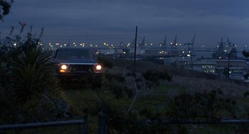 Movie still from “To Live and Die in L.A.” (1985), directed by William Friedkin – A truck is parked on the side of the road at night; Extreme Wide shot, High angle