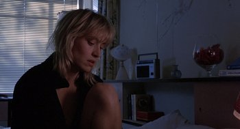 Movie still from “To Live and Die in L.A.” (1985), directed by William Friedkin – A woman sitting on a bed in the dark; Close Up shot, Low angle