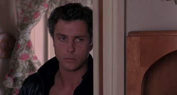 Movie still from “To Live and Die in L.A.” (1985), directed by William Friedkin – A person looking at the camera; Close Up shot, Over the shoulder angle