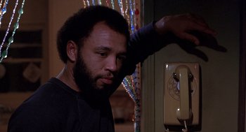 Movie still from “To Live and Die in L.A.” (1985), directed by William Friedkin – A man standing next to a wall with a phone; Close Up shot, Low angle