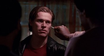 Movie still from “To Live and Die in L.A.” (1985), directed by William Friedkin – A man getting his hair cut by another man; Close Up shot, Over the shoulder angle