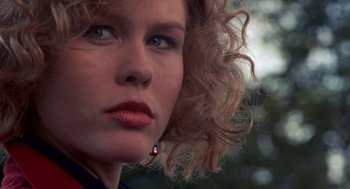 Movie still from “To Live and Die in L.A.” (1985), directed by William Friedkin – A person with curly blonde hair; Close Up shot, Low angle