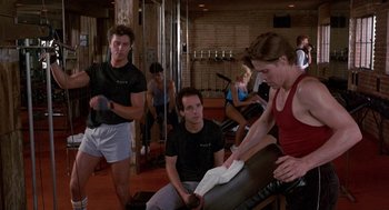 Movie still from “To Live and Die in L.A.” (1985), directed by William Friedkin – A group of people working out in a gym; Medium shot, Over the shoulder angle