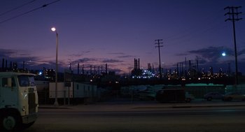 Movie still from “To Live and Die in L.A.” (1985), directed by William Friedkin – A view of an oil refinery at night from across the street; Extreme Wide shot, Low angle