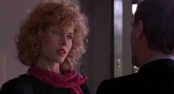 Movie still from “To Live and Die in L.A.” (1985), directed by William Friedkin – A woman wearing a pink scarf is talking to a man; Close Up shot, Over the shoulder angle