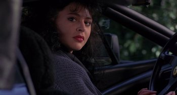 Movie still from “To Live and Die in L.A.” (1985), directed by William Friedkin – A woman sitting in the driver's seat of a car; Close Up shot, Over the shoulder angle