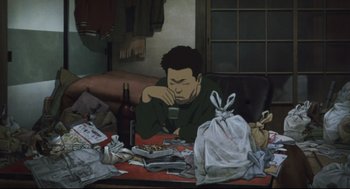 Movie still from “Tokyo Godfathers” (2003), directed by Shôgo Furuya – A man sitting at a cluttered table drinking a glass of wine; Medium shot, High angle