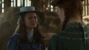 Movie still from “Anne with an E” (2017), created by Moira Walley-Beckett – A woman with a hat on and a girl with a braid in the background; Close Up shot, Over the shoulder angle
