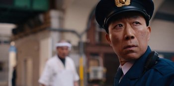 Movie still from “Tokyo Vice” (2022), created by J.T. Rogers – A person wearing a uniform; Close Up shot, Low angle