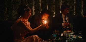 Movie still from “Tokyo Vice” (2022), created by J.T. Rogers – A man and a woman sitting at a table with a lit candle; Medium shot, Over the shoulder angle