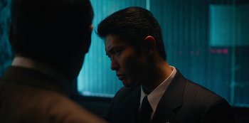 Movie still from “Tokyo Vice” (2022), created by J.T. Rogers – A man wearing a suit and tie talking to another man in a suit; Close Up shot, Over the shoulder angle