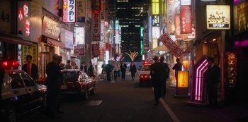 Movie still from “Tokyo Vice” (2022), created by J.T. Rogers – People walking down a street at night in a city; Extreme Wide shot, High angle
