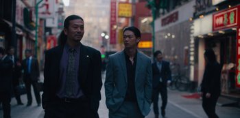 Movie still from “Tokyo Vice” (2022), created by J.T. Rogers – Two men in suits are walking down the street; Medium shot, Low angle