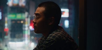 Movie still from “Tokyo Vice” (2022), created by J.T. Rogers – A man with glasses is looking into the distance; Close Up shot, Low angle