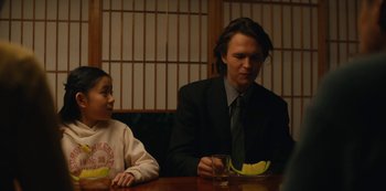 Movie still from “Tokyo Vice” (2022), created by J.T. Rogers – A man in a suit sitting at a table with a child; Medium shot, Over the shoulder angle