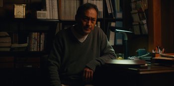 Movie still from “Tokyo Vice” (2022), created by J.T. Rogers – A man sitting at a desk in a room; Medium shot, Low angle