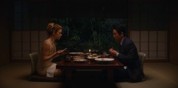 Movie still from “Tokyo Vice” (2022), created by J.T. Rogers – A man and a woman sitting at a dinner table; Medium shot, High angle