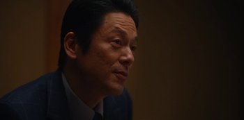 Movie still from “Tokyo Vice” (2022), created by J.T. Rogers – A person wearing a suit and tie; Close Up shot, Low angle