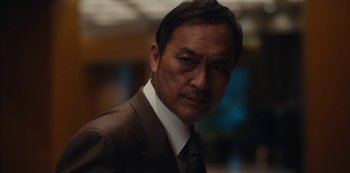 Movie still from “Tokyo Vice” (2022), created by J.T. Rogers – A person wearing a suit and tie; Close Up shot, Low angle